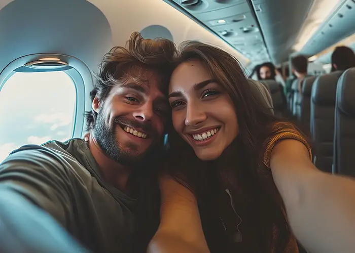 Two people leaning close together inside an airplane cabin