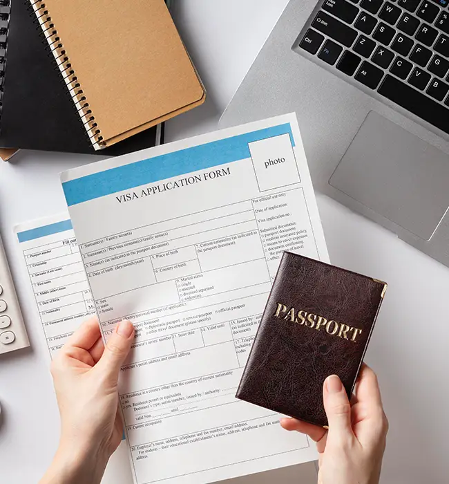 a hand holding visa application form and passport 
