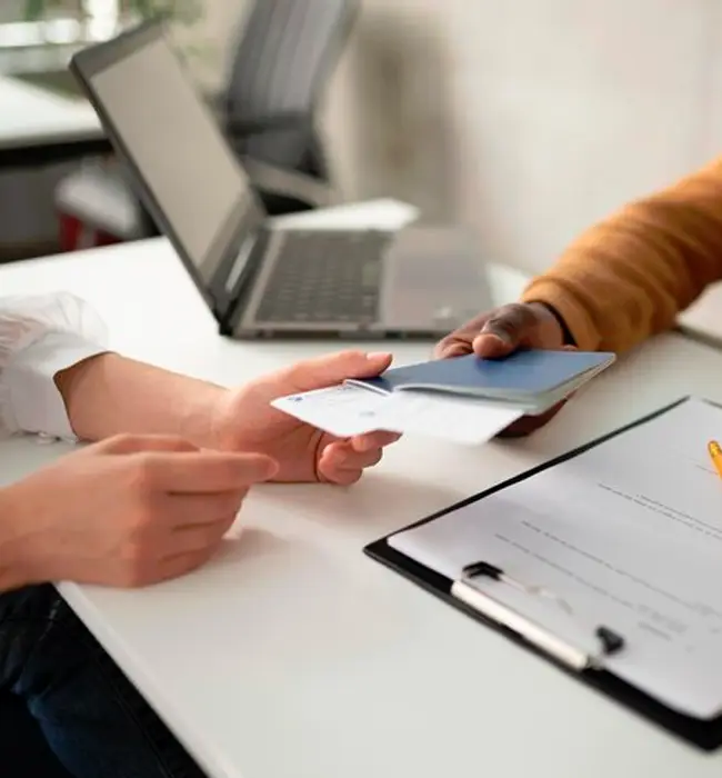 a travel agent hands over the passport and flight ticket to the customer
