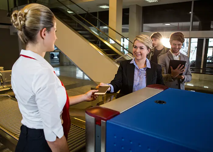lady traveller hands over the passport and boarding pass to the airport officials