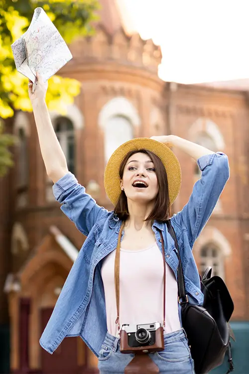 a young lady traveller with hat, camera, bag and world map