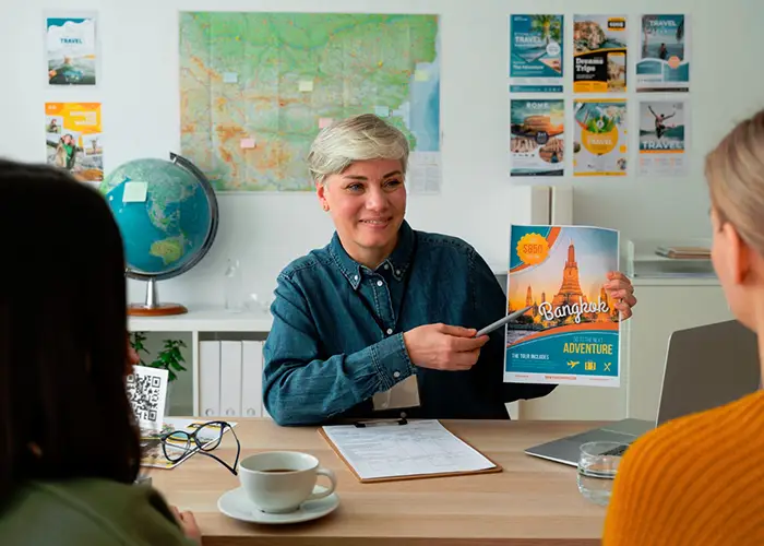 travel agent shows the bangkong itinerary to the customers, globe and world map in the background