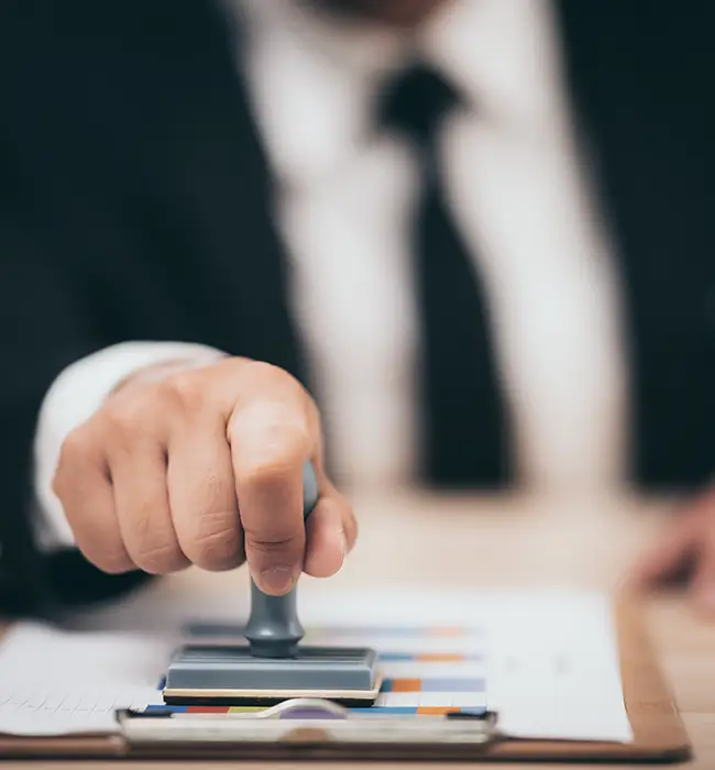 a hand held stamp presses against the visa stamping paper